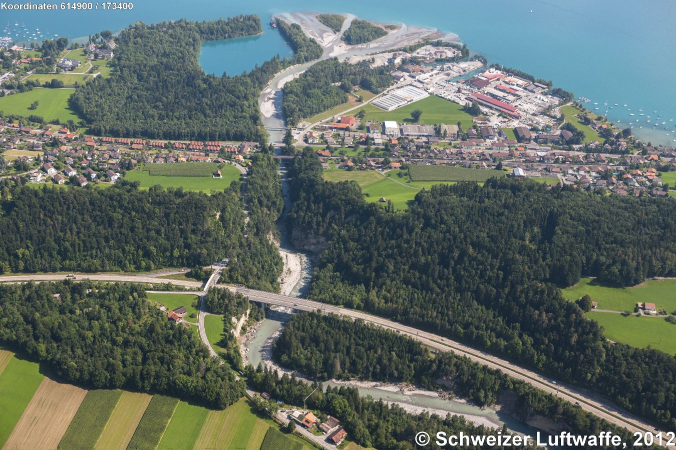 Kanderdurchstich (Position:2'614'858.42, 1'173'255.03) Im Vordergrund: Autobahn A6 mit Kanderbrücke 'Hani'. Durchstich der Kander beim 'Chanderbort'. Fussgängersteg 'Strättlisteg', danach Eisenbahnbrücke, Brücke Hauptstrasse, am Schluss 'Chanderbrügg' Quartierstrasse. Mündung der Kander bei Gwatt in den Thunersee. Delta 'Chandergrien'.
